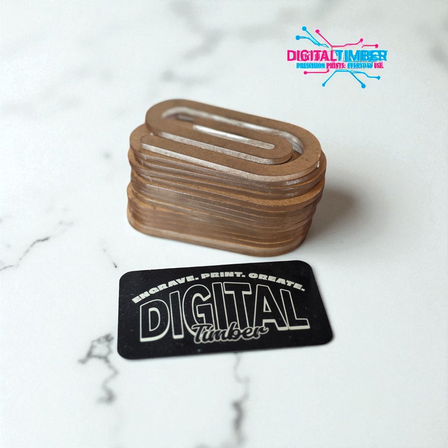 Stack of engraved wooden coasters with 'Digital Timber' branding on a marble surface.