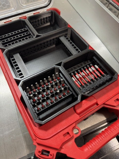 Milwaukee short bit holders in a red bin organizer.